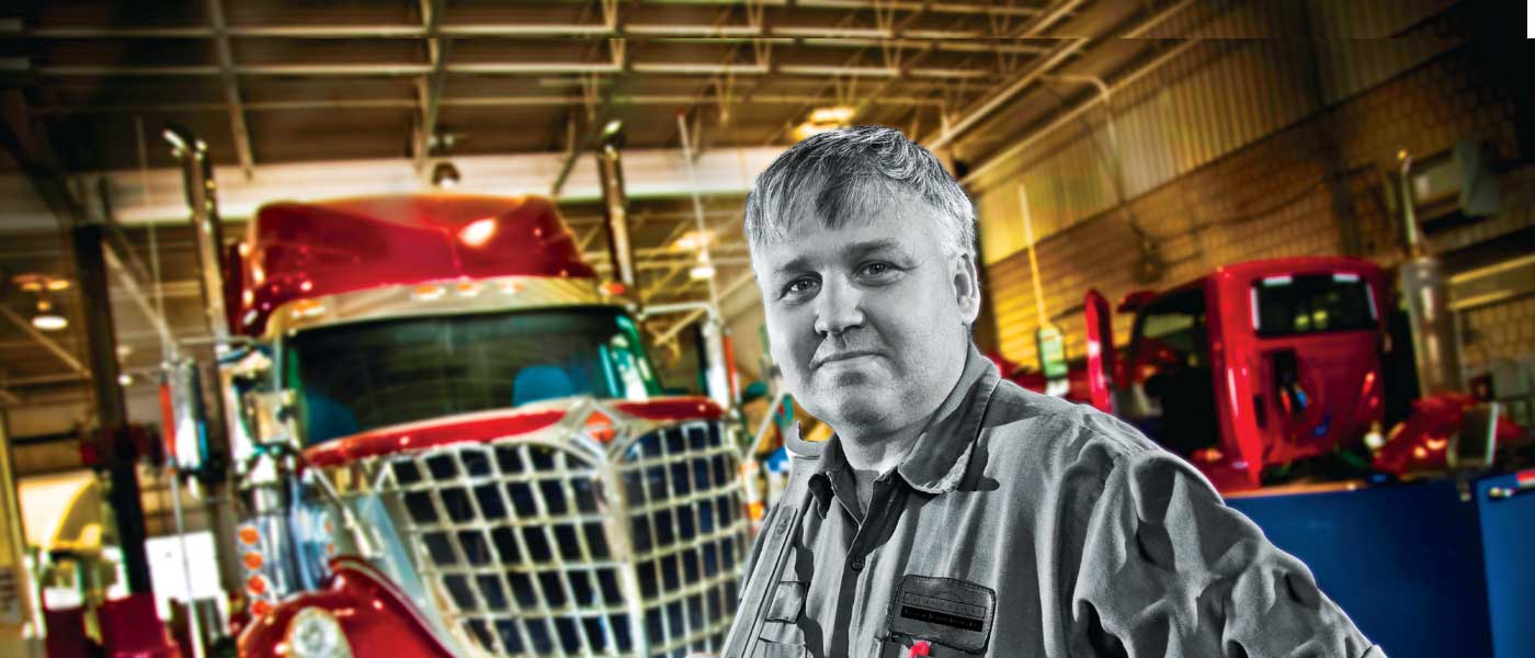 Man standing in front of semi inside a garage